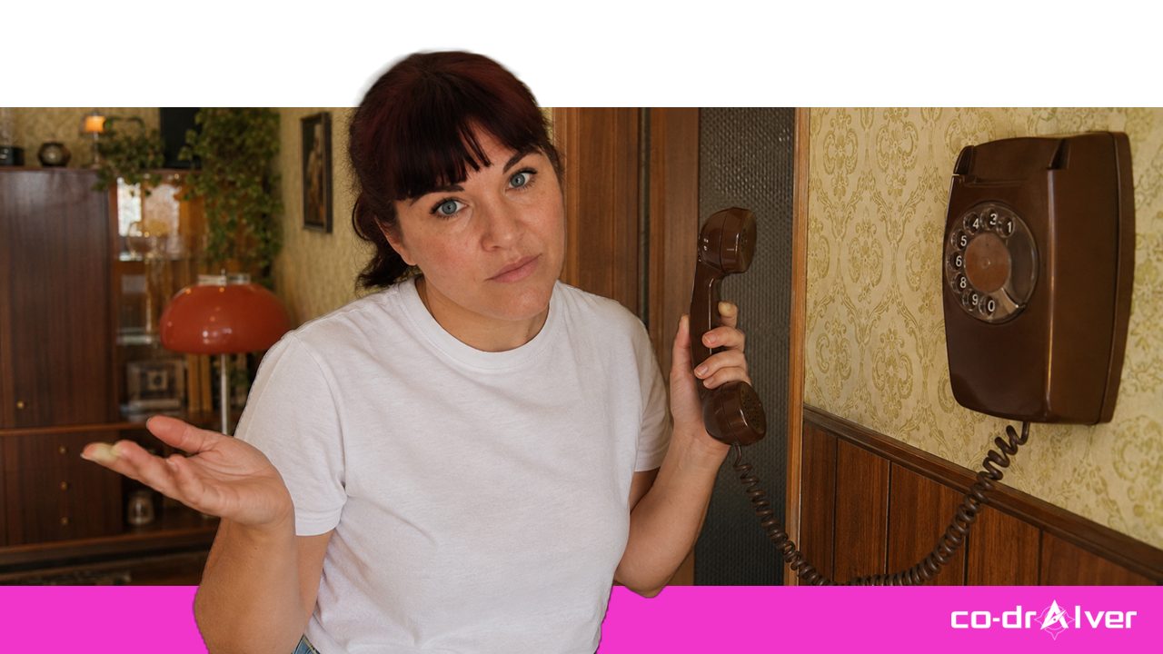 Frau mit altem Wählscheibentelefon, ratlos: Sinnbild für Fähigkeiten, die wir nach und nach an Technik abgegeben haben.